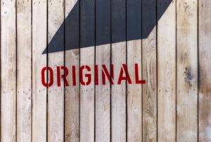木の板で作られた壁にペイントされているORIGINALという文字の画像