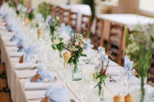 テーブルに名前の書いた袋と花と食器が置かれている画像