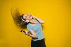女性が携帯で音楽を聴きながら髪を振り回している画像
